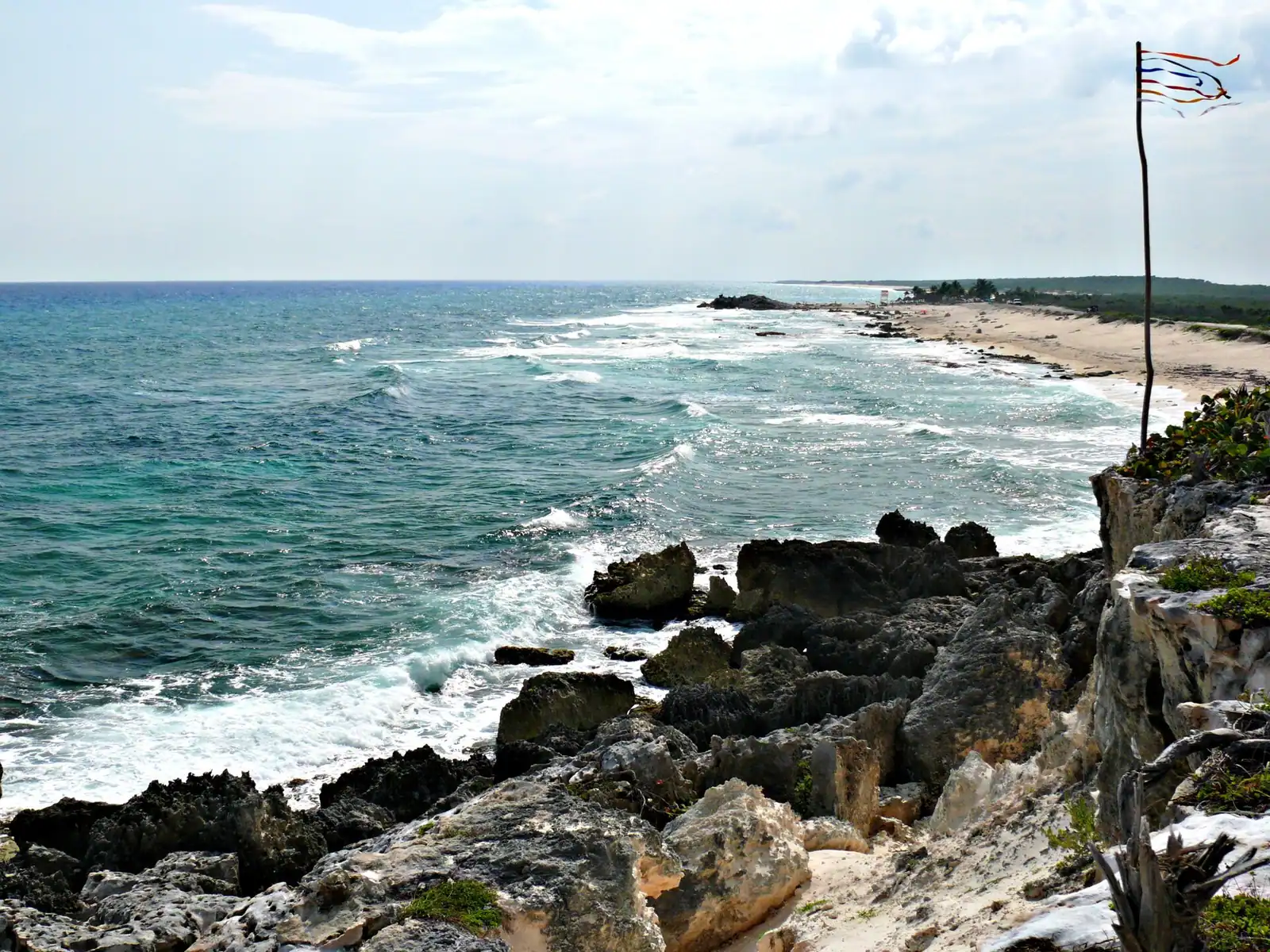 View from a low coastal cliff over open ocean with surf lines breaking offshore